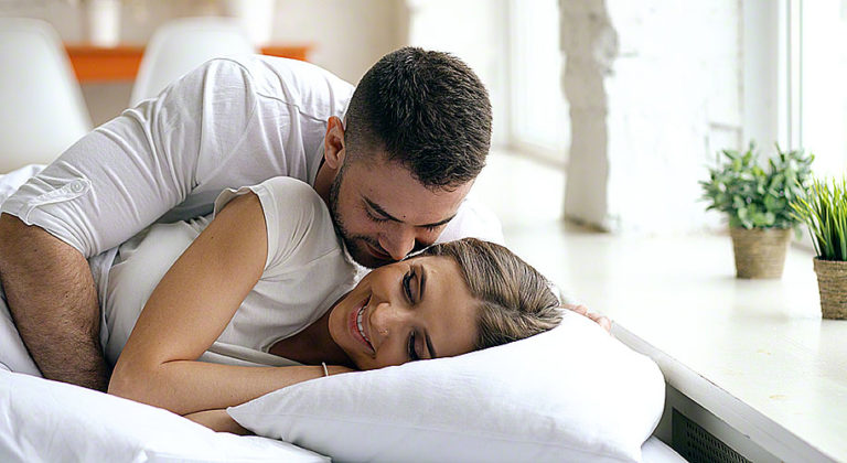 Young beautiful and loving couple wake up at the morning. Attractive ...